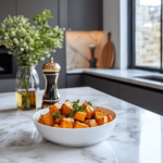 Elegant roasted sweet potato dish in a modern luxury kitchen with marble countertops.